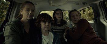 Movie still from “The Silence” (2019), directed by John R. Leonetti – A group of people sitting in the back of a car; Medium shot, High angle