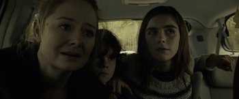 Movie still from “The Silence” (2019), directed by John R. Leonetti – Three people in the back seat of a car; Close Up shot, Low angle