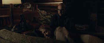 Movie still from “The Silence” (2019), directed by John R. Leonetti – A man and a girl sleeping on a bed; Medium shot, Over the shoulder angle