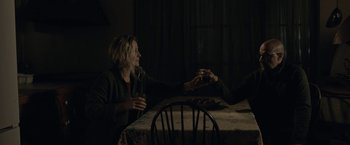 Movie still from “The Silence” (2019), directed by John R. Leonetti – A woman sitting at a table with a glass of wine; Medium shot, Over the shoulder angle