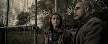 Movie still from “The Silence” (2019), directed by John R. Leonetti – A young woman standing next to a man in front of a fence; Medium shot, Over the shoulder angle