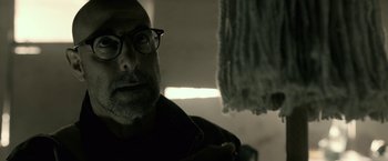 Movie still from “The Silence” (2019), directed by John R. Leonetti – A person wearing glasses and a jacket; Close Up shot, Low angle
