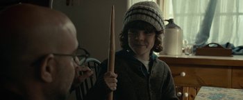 Movie still from “The Silence” (2019), directed by John R. Leonetti – A young boy holding up a pair of knitting needles; Close Up shot, Over the shoulder angle