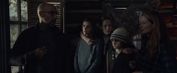 Movie still from “The Silence” (2019), directed by John R. Leonetti – A group of people standing next to each other in a room; Medium shot, Over the shoulder angle