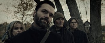 Movie still from “The Silence” (2019), directed by John R. Leonetti – A group of men standing next to each other in front of a tree; Close Up shot, Low angle