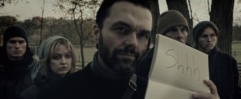 Movie still from “The Silence” (2019), directed by John R. Leonetti – A person holding a book; Close Up shot, Over the shoulder angle