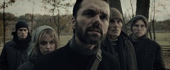 Movie still from “The Silence” (2019), directed by John R. Leonetti – A group of people standing next to each other in a park; Close Up shot, Low angle
