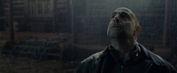Movie still from “The Silence” (2019), directed by John R. Leonetti – A man standing in the rain with his eyes wide open; Close Up shot, Low angle