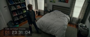 Movie still from “The Social Dilemma” (2020), directed by Jeff Orlowski-Yang – A man standing in front of a bed in a room; Wide shot, High angle