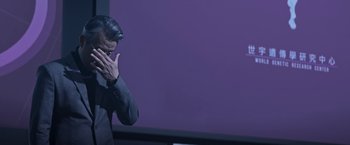 Movie still from “The Soul” (2021), directed by Wei-Hao Cheng – A man standing in front of a purple wall holding his hands to his face; Medium shot, Over the shoulder angle