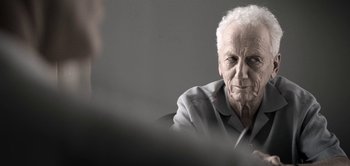 Movie still from “The Spy” (2019), directed by Gideon Raff – An older man sitting in front of another man; Close Up shot, Over the shoulder angle