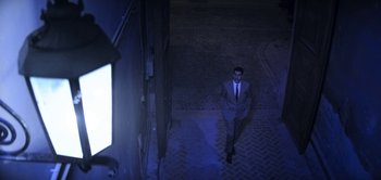 Movie still from “The Spy” (2019), directed by Gideon Raff – A man in a suit and tie walking down a hallway; Wide shot, Low angle
