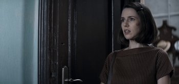 Movie still from “The Spy” (2019), directed by Gideon Raff – A woman standing in front of a door looking to her left; Close Up shot, Over the shoulder angle