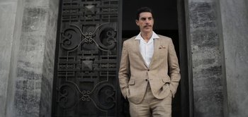 Movie still from “The Spy” (2019), directed by Gideon Raff – A man standing in front of an ornate metal door; Medium shot, Low angle
