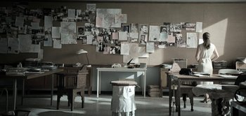 Movie still from “The Spy” (2019), directed by Gideon Raff – A room filled with lots of papers on the wall; Wide shot, High angle