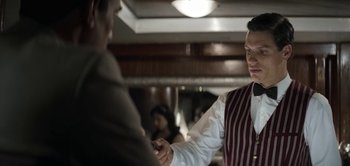 Movie still from “The Spy” (2019), directed by Gideon Raff – A man shaking hands with another man in front of a mirror; Medium shot, Over the shoulder angle