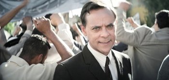 Movie still from “The Spy” (2019), directed by Gideon Raff – A person wearing a suit and tie; Close Up shot, High angle