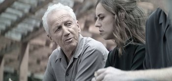 Movie still from “The Spy” (2019), directed by Gideon Raff – An older man and a younger woman are talking; Close Up shot, Over the shoulder angle