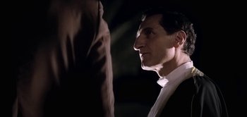 Movie still from “The Spy” (2019), directed by Gideon Raff – A person wearing a suit and tie; Close Up shot, Over the shoulder angle