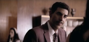 Movie still from “The Spy” (2019), directed by Gideon Raff – A person wearing a suit and tie; Close Up shot, Over the shoulder angle