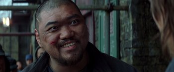 Movie still from “Batman Begins” (2005), directed by Christopher Nolan – A person with a shaved head; Close Up shot, Low angle