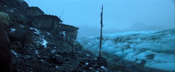 Movie still from “Batman Begins” (2005), directed by Christopher Nolan – A building that is sitting on the side of a mountain; Extreme Wide shot, Low angle