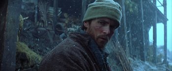 Movie still from “Batman Begins” (2005), directed by Christopher Nolan – A person wearing a hat and a jacket; Close Up shot, Low angle