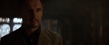 Movie still from “Batman Begins” (2005), directed by Christopher Nolan – A person wearing a suit and tie; Close Up shot, Over the shoulder angle