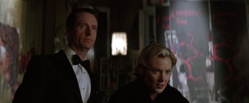 Movie still from “Batman Begins” (2005), directed by Christopher Nolan – A man and a woman standing next to each other in a room; Close Up shot, Low angle