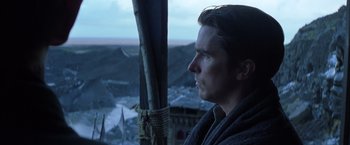Movie still from “Batman Begins” (2005), directed by Christopher Nolan – A person looking out of a window; Close Up shot, Low angle