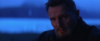 Movie still from “Batman Begins” (2005), directed by Christopher Nolan – A person with a beard; Close Up shot, Over the shoulder angle