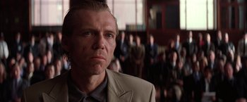 Movie still from “Batman Begins” (2005), directed by Christopher Nolan – A person wearing a suit and tie; Close Up shot, Low angle