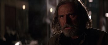Movie still from “Batman Begins” (2005), directed by Christopher Nolan – An old man with long hair and a beard; Close Up shot, Low angle
