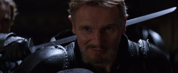 Movie still from “Batman Begins” (2005), directed by Christopher Nolan – A person with a beard; Close Up shot, Low angle