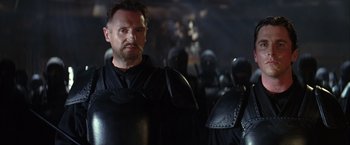 Movie still from “Batman Begins” (2005), directed by Christopher Nolan – A person wearing armor; Medium shot, Over the shoulder angle