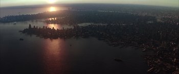 Movie still from “Batman Begins” (2005), directed by Christopher Nolan – An aerial view of a large city at sunset; Extreme Wide shot, High angle