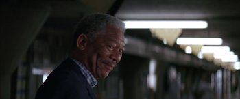 Movie still from “Batman Begins” (2005), directed by Christopher Nolan – An older man is smiling for the camera; Close Up shot, Low angle