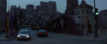 Movie still from “Batman Begins” (2005), directed by Christopher Nolan – A car is driving down the street at night; Extreme Wide shot, High angle
