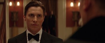 Movie still from “Batman Begins” (2005), directed by Christopher Nolan – A person wearing a tuxedo; Close Up shot, Low angle