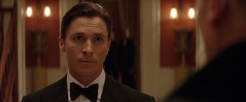 Movie still from “Batman Begins” (2005), directed by Christopher Nolan – A man in a suit and bow tie; Close Up shot, Low angle