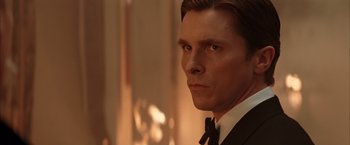 Movie still from “Batman Begins” (2005), directed by Christopher Nolan – A man in a suit and a tie; Close Up shot, Over the shoulder angle