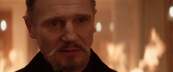 Movie still from “Batman Begins” (2005), directed by Christopher Nolan – A person with a beard; Close Up shot, Over the shoulder angle