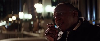 Movie still from “Batman Begins” (2005), directed by Christopher Nolan – A person holding a cell phone; Close Up shot, Low angle