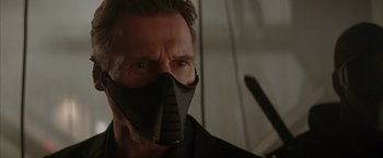 Movie still from “Batman Begins” (2005), directed by Christopher Nolan – A person wearing a face mask; Close Up shot, Low angle