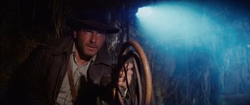 Movie still from “Raiders of the Lost Ark” (1981), directed by Steven Spielberg – A person holding a steering wheel; Medium shot, Low angle