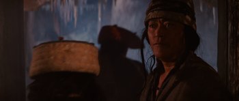 Movie still from “Raiders of the Lost Ark” (1981), directed by Steven Spielberg – A man with a long black hair and a hat on his head; Close Up shot, Low angle