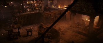 Movie still from “Raiders of the Lost Ark” (1981), directed by Steven Spielberg – A man sitting in front of an open fireplace; Wide shot, High angle