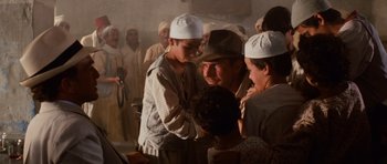 Movie still from “Raiders of the Lost Ark” (1981), directed by Steven Spielberg – A group of people standing in a room; Medium shot, Over the shoulder angle