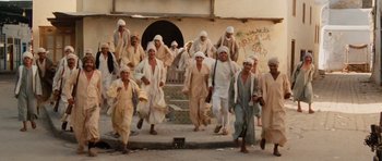 Movie still from “Raiders of the Lost Ark” (1981), directed by Steven Spielberg – A group of men are walking down the street; Wide shot, High angle