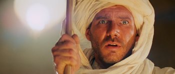 Movie still from “Raiders of the Lost Ark” (1981), directed by Steven Spielberg – A person holding a wooden stick; Close Up shot, Low angle